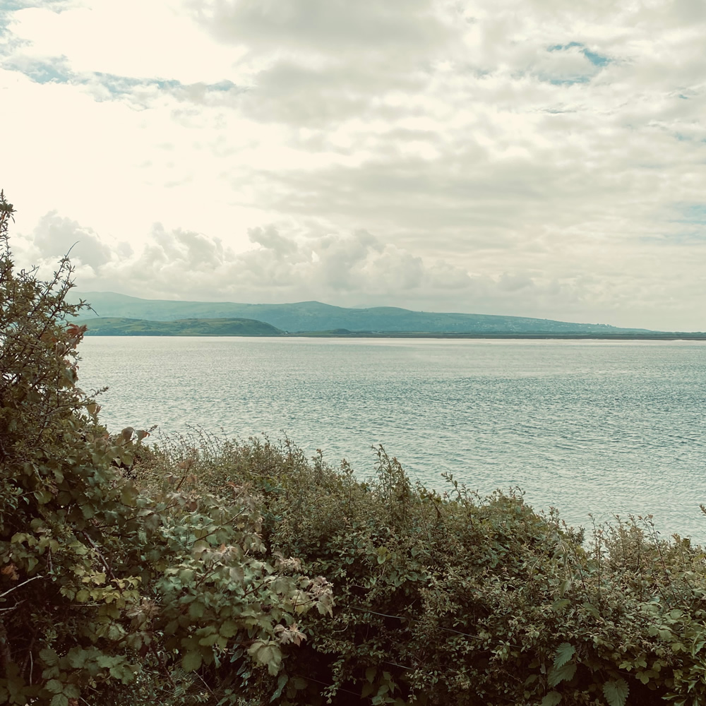 A view of the sea, mountains and clouds at Borth-y-Gest, Wales