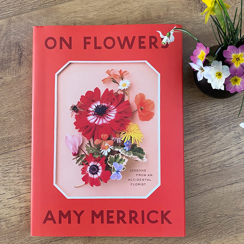 On Flowers book and a vase of small, spring flowers